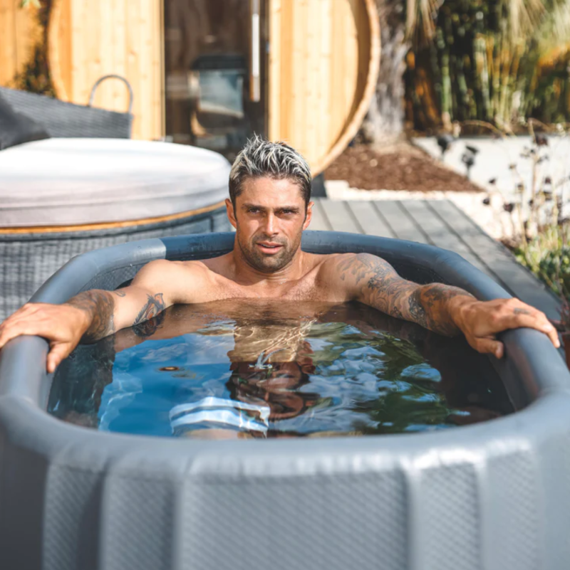 A man using a Cold Therapy Tru Grit Inflatable Tub in an Outdoor Setting.