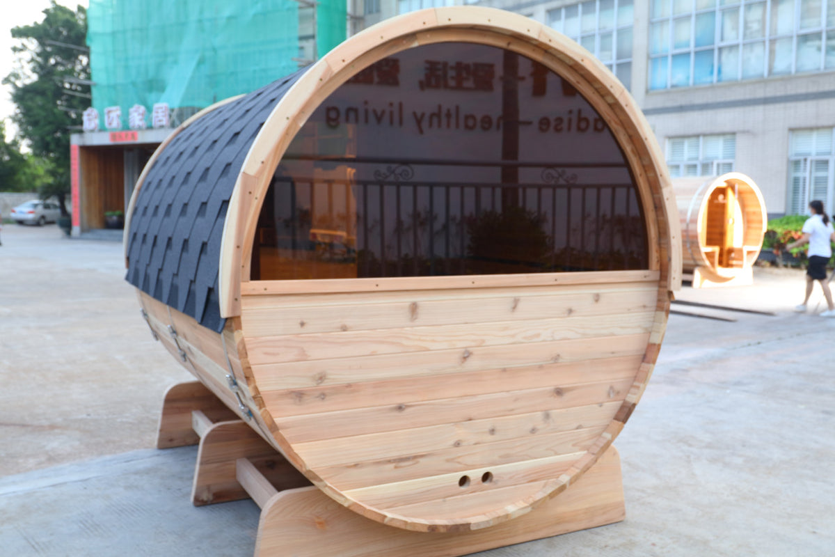 Back view of Aleko Red Cedar Wet/Dry Outdoor Barrel Sauna with Front Porch Canopy, Panoramic View, Butimen Shingle Roofing and 8 kW KIP Harvia Electric Sauna Heater.