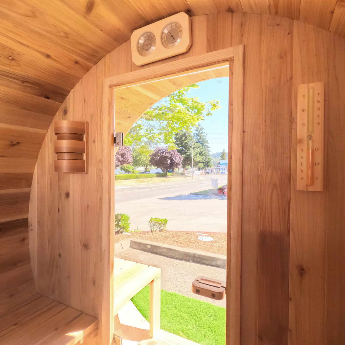 Inside view of Aleko Red Cedar Wet/Dry Outdoor Barrel Sauna with Front Porch Canopy, Panoramic View, Butimen Shingle Roofing and 8 kW KIP Harvia Electric Sauna Heater.