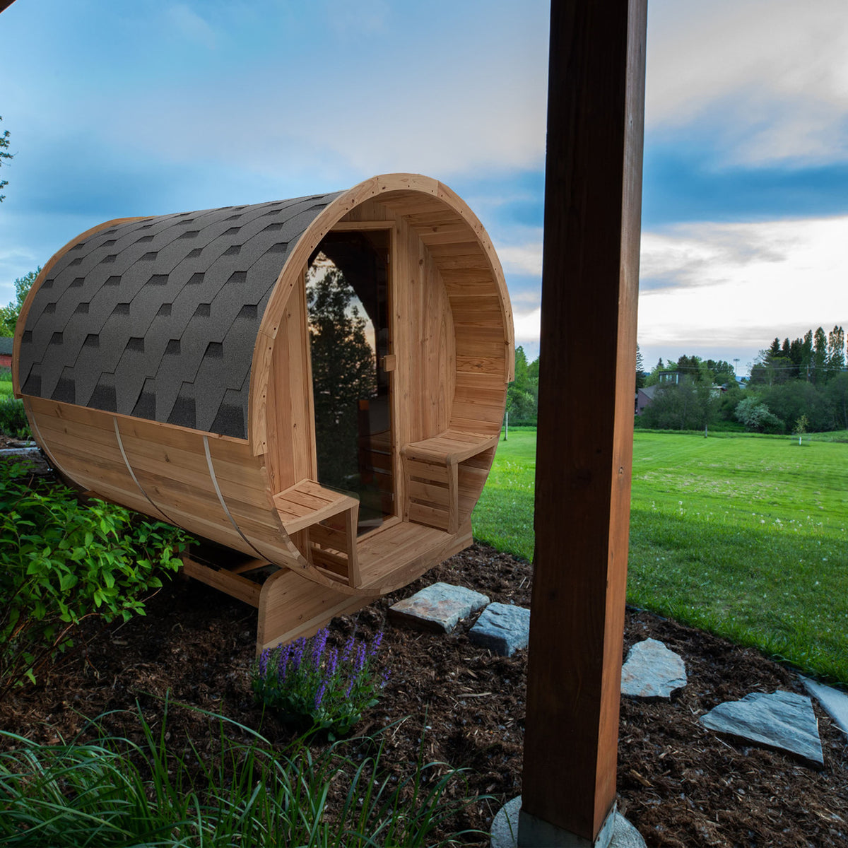 Aleko Rustic Cedar 3/4 Person Outdoor Barrel Sauna with Front Porch Canopy and 4.5 kW Electric Sauna Heater in a nature setting.