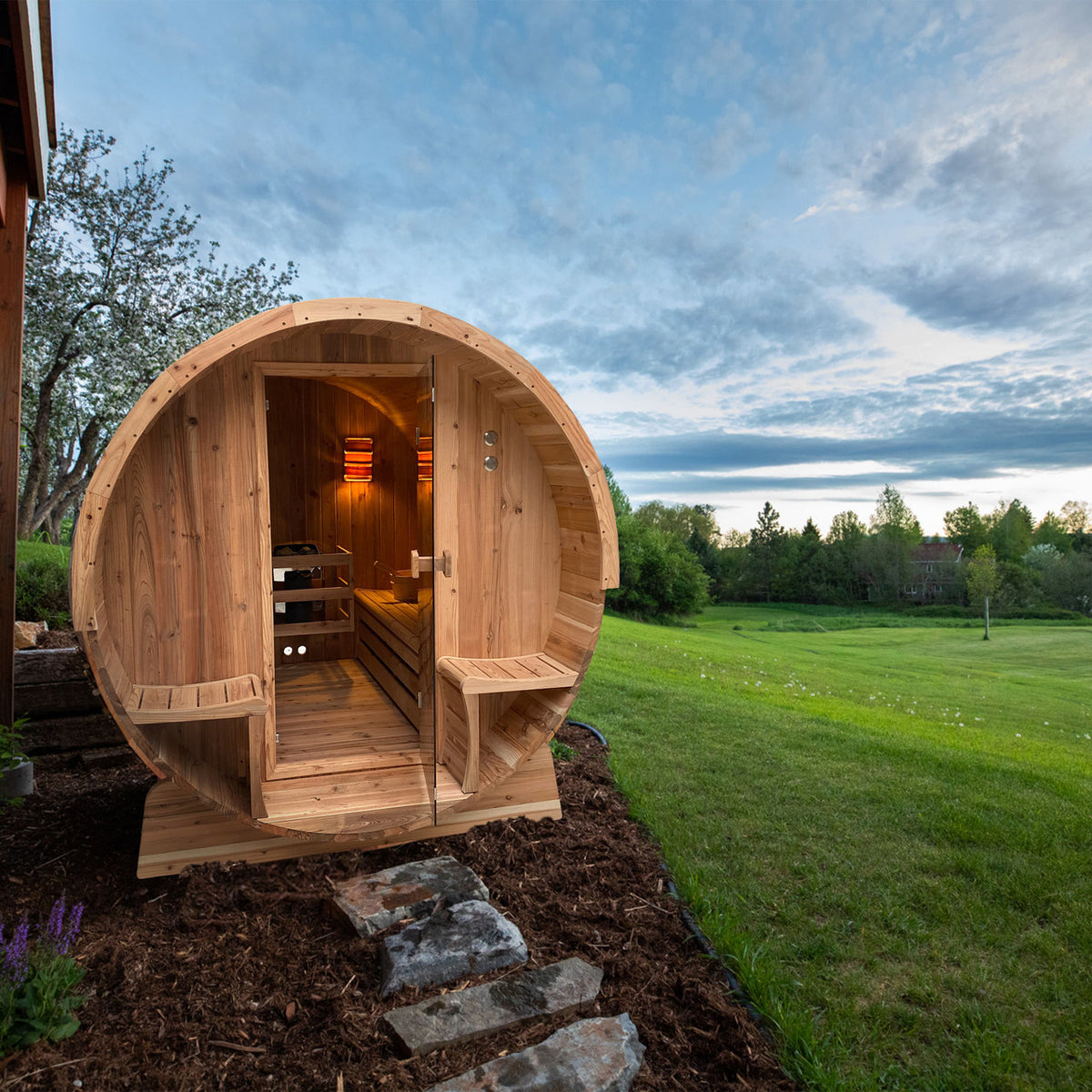 Aleko Rustic Cedar 3/4 Person Outdoor Barrel Sauna with Front Porch Canopy and 4.5 kW Electric Sauna Heater open, showing the interior, in a natural setting.