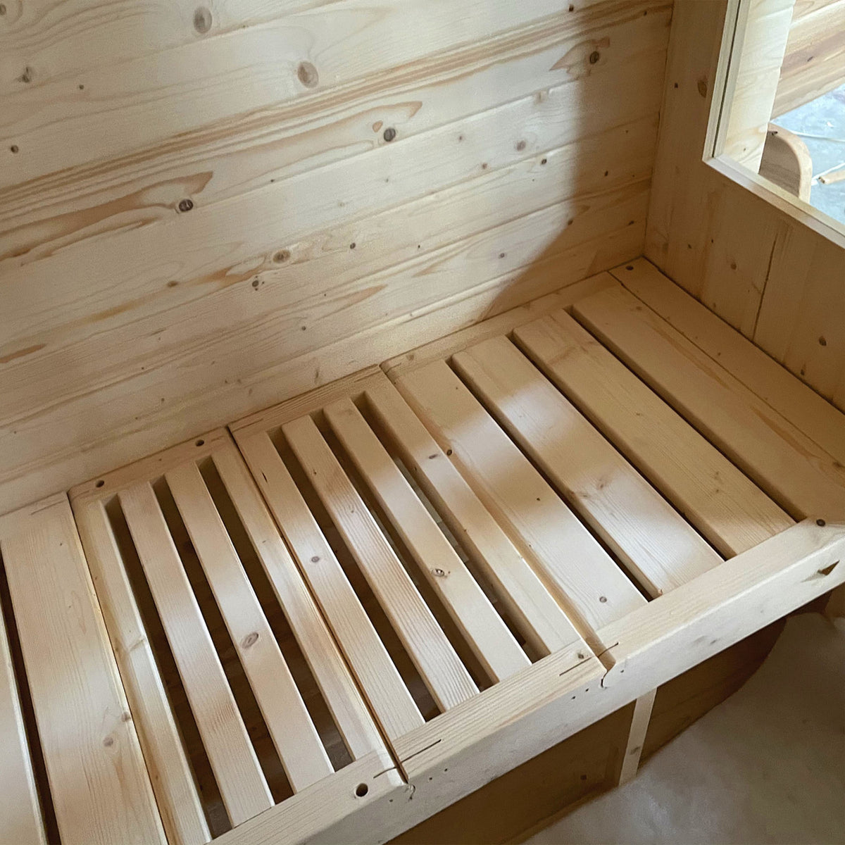 Lounging bench of Aleko Rustic Cedar Square Outdoor Sauna 4 Person with 4.5 kW Electric Sauna Heater in straight position.