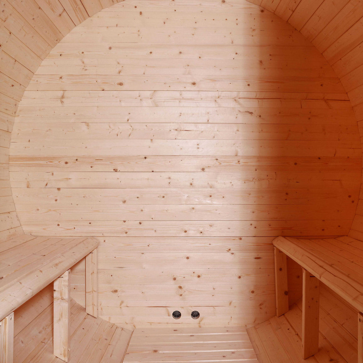 Interior view of Aleko White Finland Pine 3/4 Person Outdoor Barrel Sauna with Black Accents and 4.5 kW Harvia KIP Electric Sauna Heater showing the back wall and the benches.