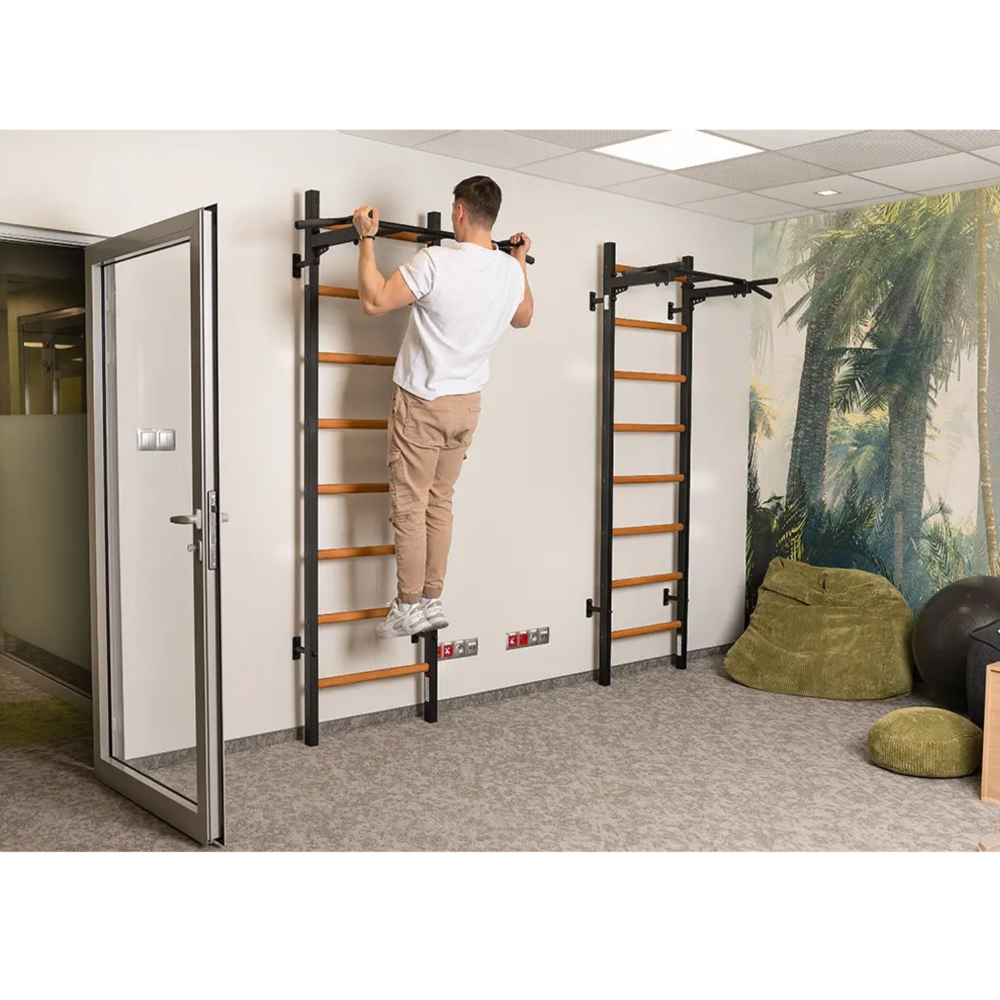 A man doing pull ups with a BenchK 221 Wall Bars and Gymnastic Ladders black version.