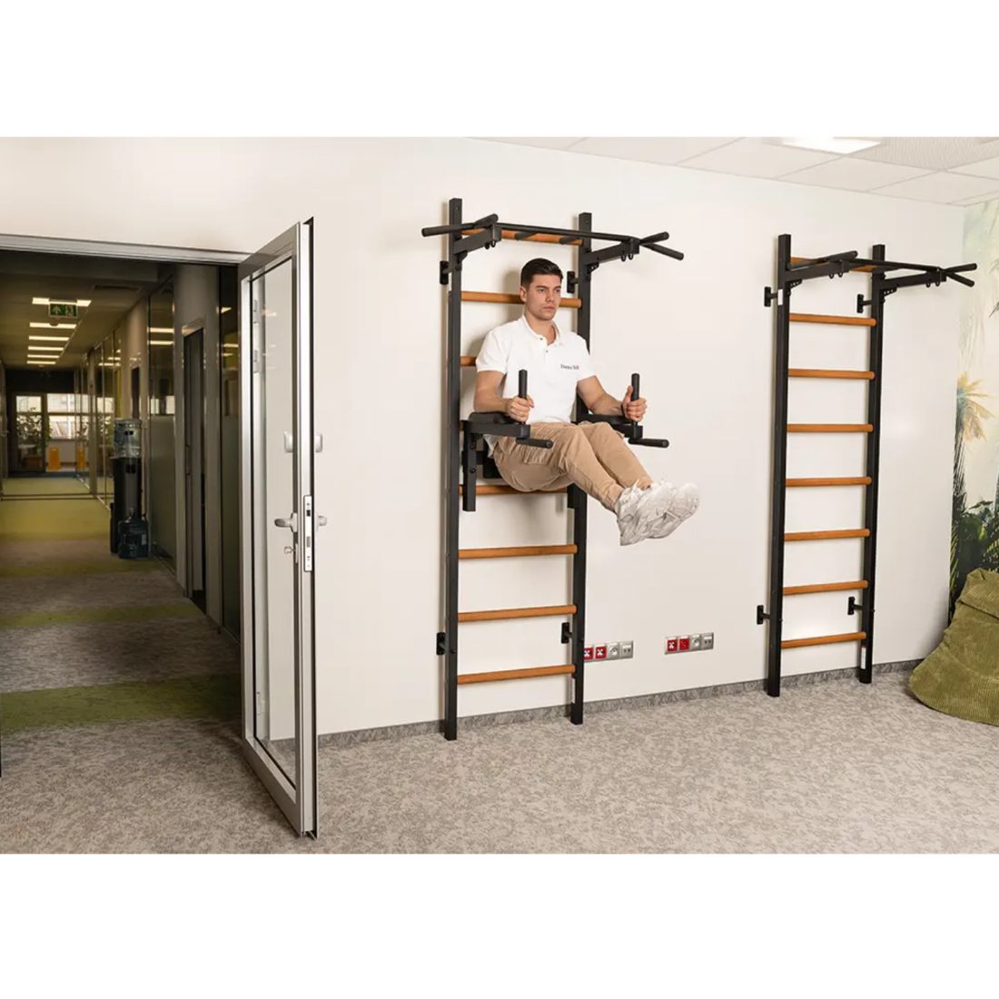 A man using a BenchK 222 Wall Bars and Gymnastic Ladders black version.