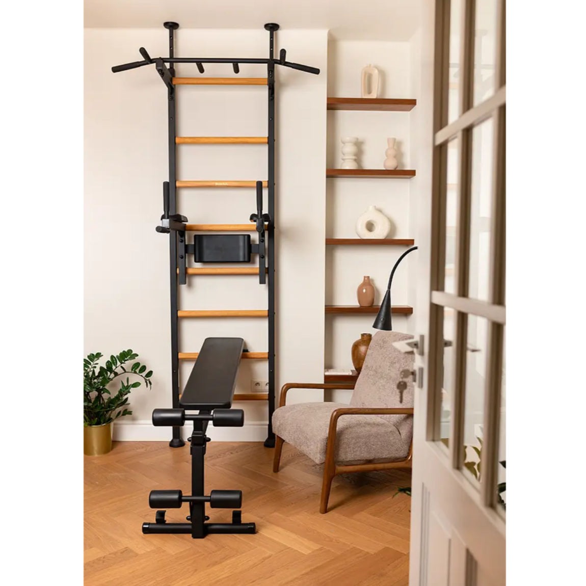 BenchK 523 Wall Bars and Gymnastic Ladders black version with workout bench installed in a living room.