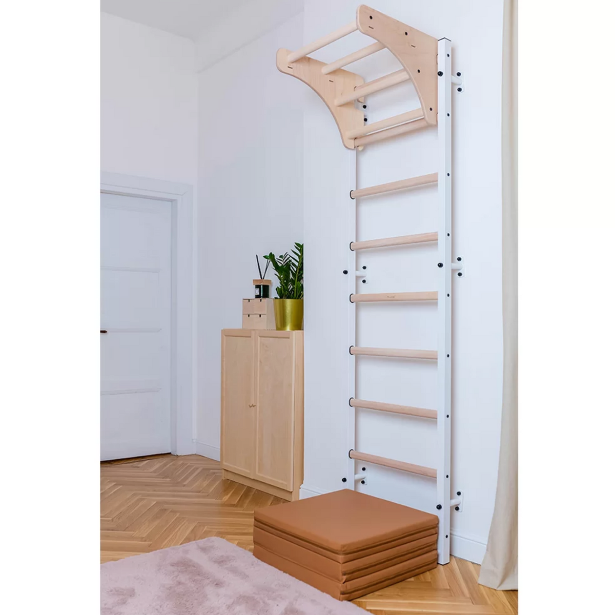 BenchK 711 Wall Bars and Gymnastic Ladders with wooden pull-up bar white version installed in a living room.