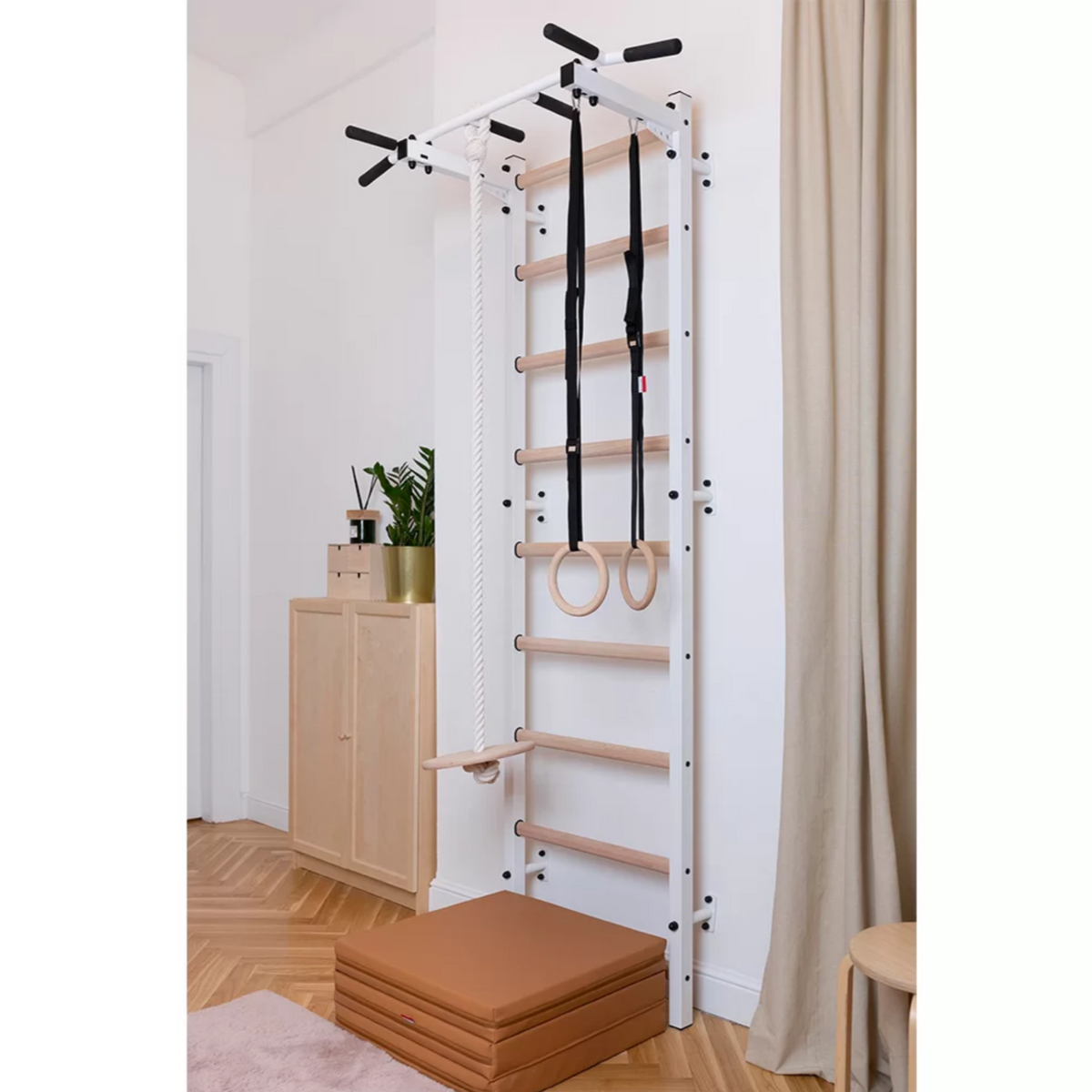 BenchK 721 Wall Bars + A076/A204 Gymnastic Accessories white version installed in a bedroom.