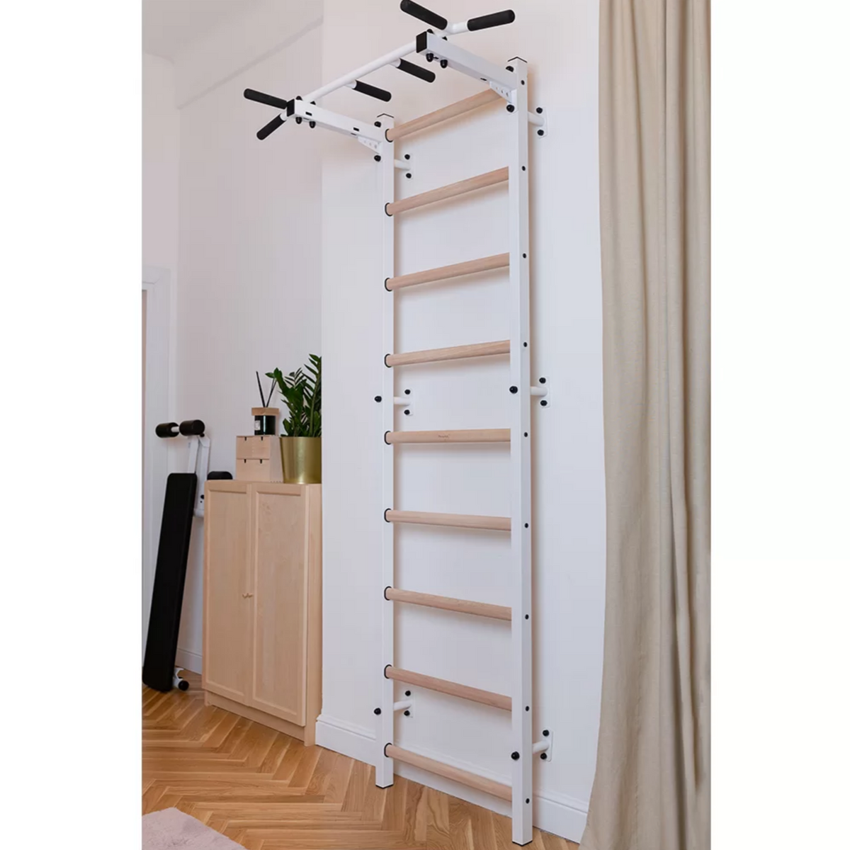 BenchK 721 Wall Bars and Gymnastic Ladders with pull-up bar white version installed in a living room.