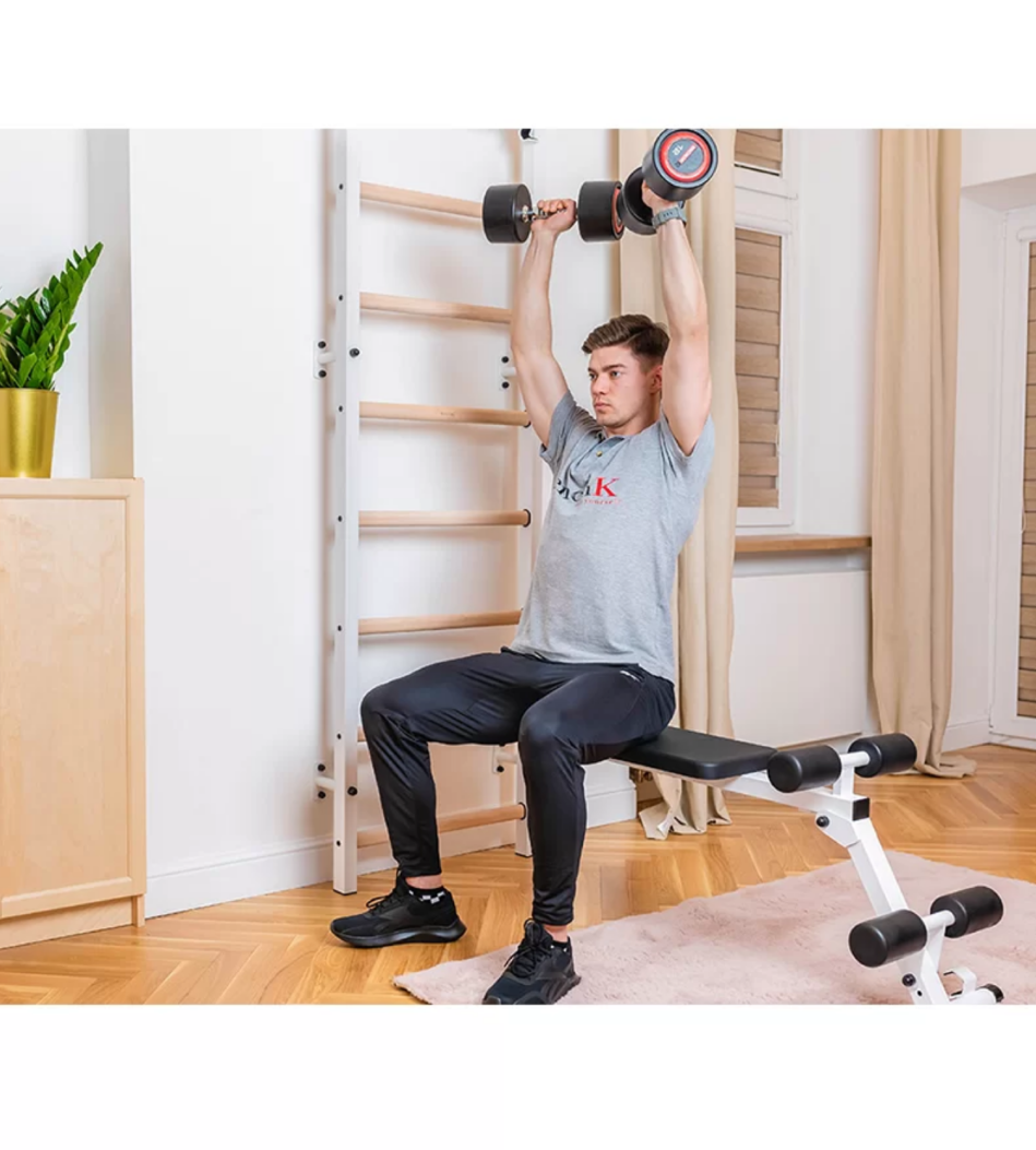 A man having a gym session with BenchK 723 Wall Bars and Gymnastic Ladders white version.