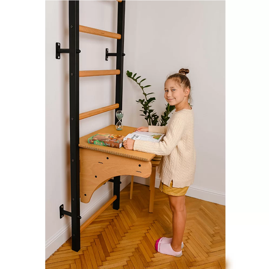 A child using BenchK BenchTop for Wall Bars oak version as a standing desk.