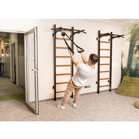 A man exercising with a TRX attached to BenchK PB2 Steel Pull-Up Bar black version.