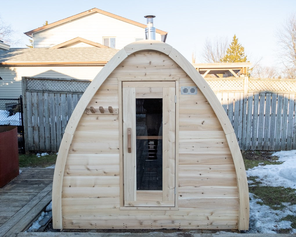 Front view of MiniPOD Outdoor Sauna in a garden with the door closed. 