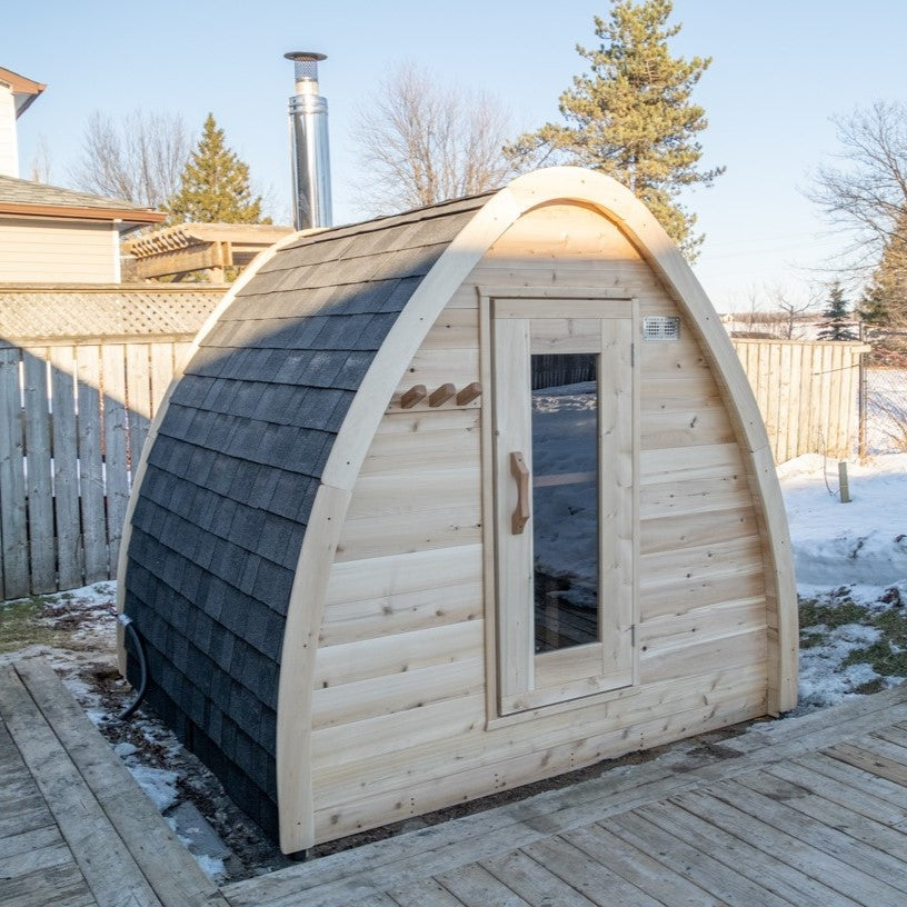 Main view of MiniPOD Outdoor Sauna in an outdoor setting in winder, surrounded by snow. 