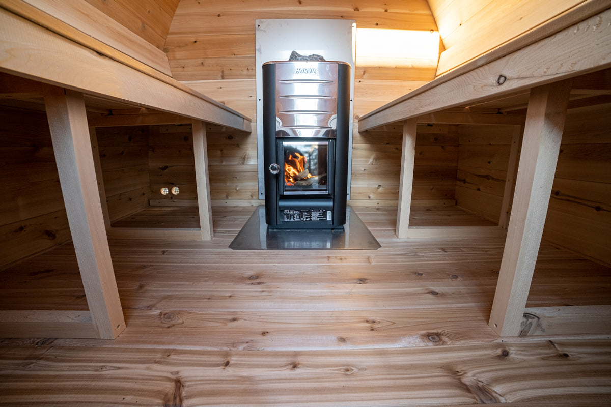 Inside view of the MiniPOD Outdoor Sauna with a focus on the floor and heater. 