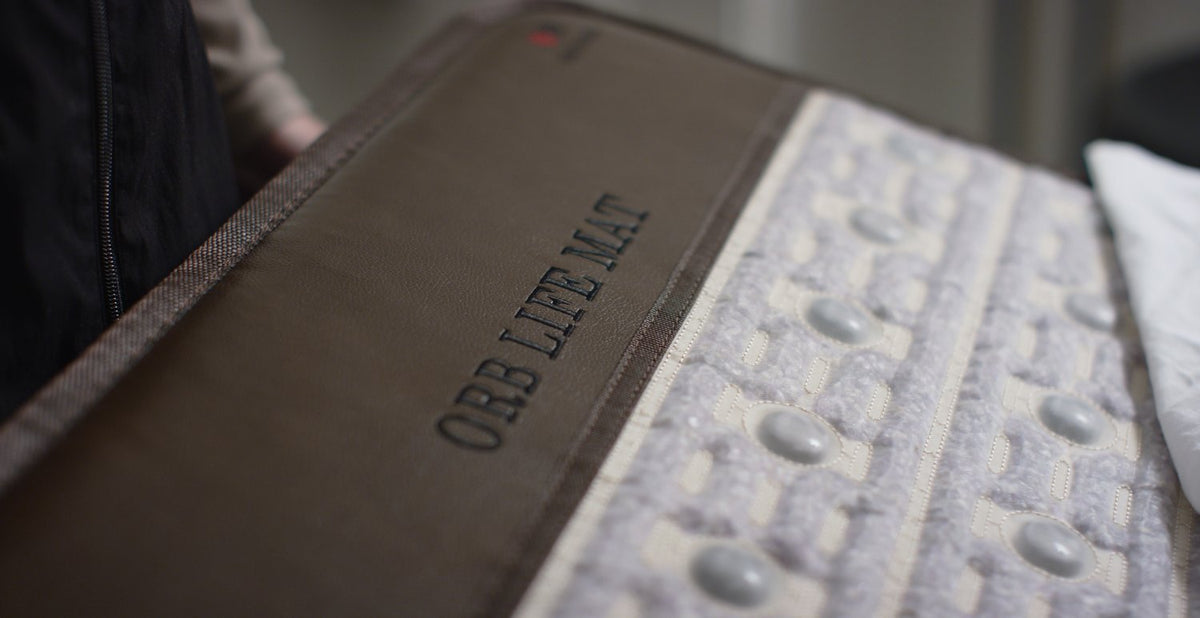 Close-up view of the ORB PEMF therapeutic mat highlighting the logo and texture design for holistic wellness.