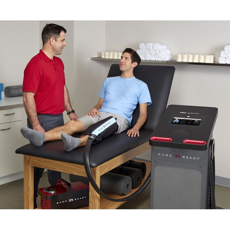 A doctor treating the leg of one of its patients with Game Ready Med4 Elite Contrast and Compression Multi-Modality Therapy Unit.