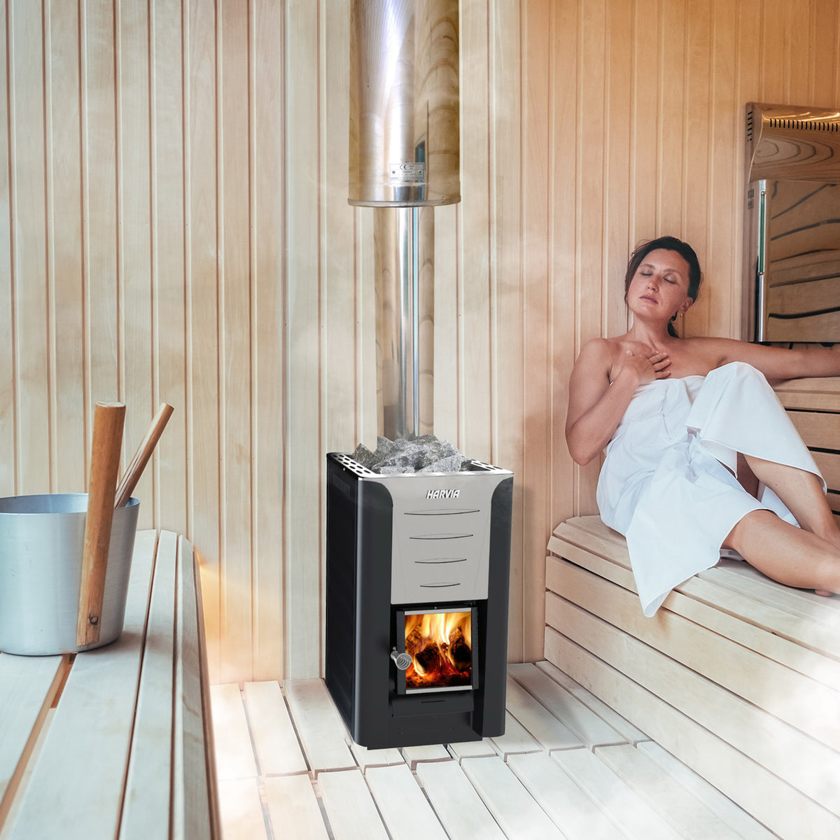 A woman using a Harvia Pro 20 Wood Burning Sauna Heater and Chimney Kit in a sauna.