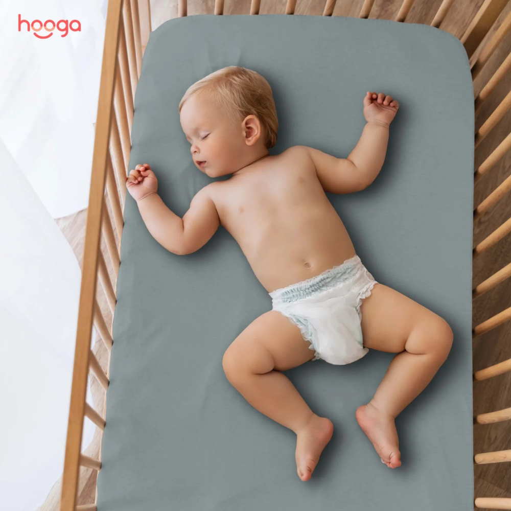 A baby using a Hooga Grounding Crib Sheet. 