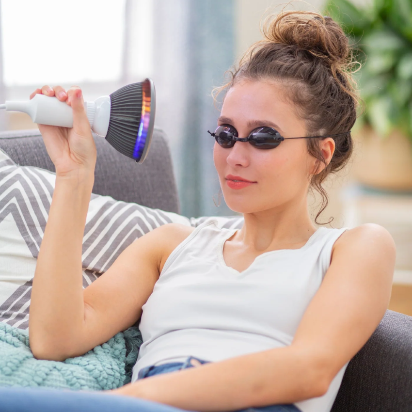 A woman using a Hooga Orange LED Light Therapy.