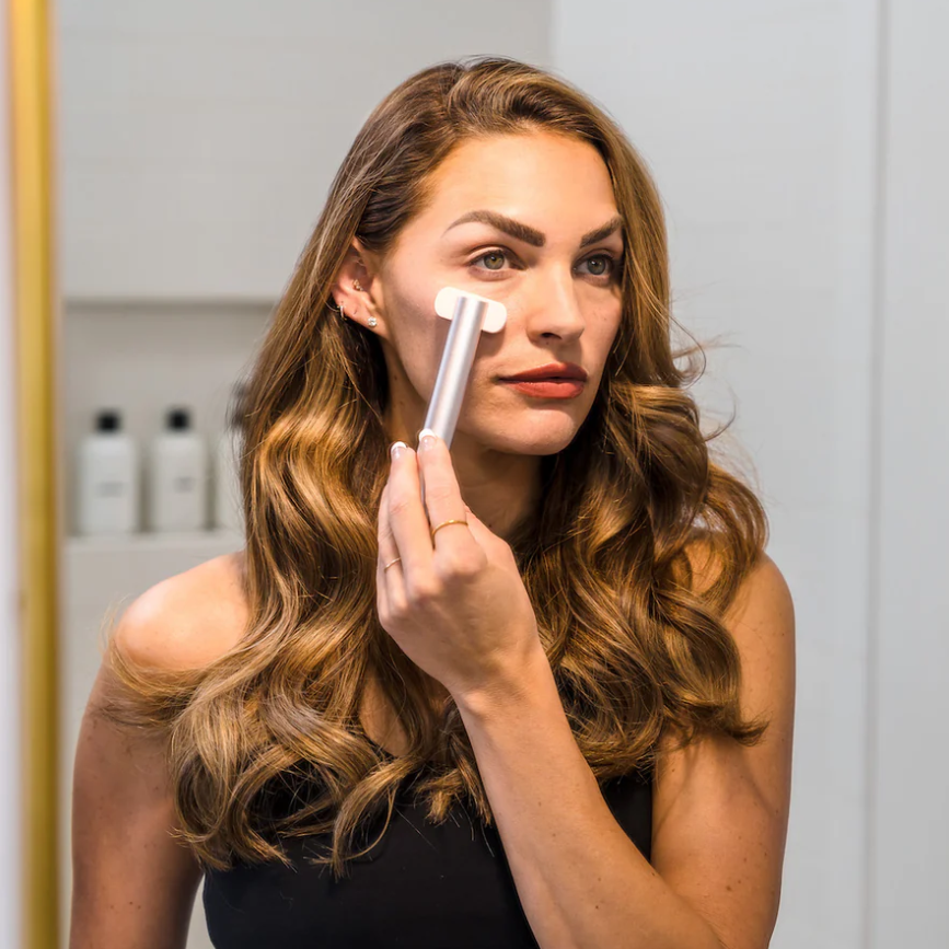 A woman using a Hooga Red Light Therapy Facial Wand.