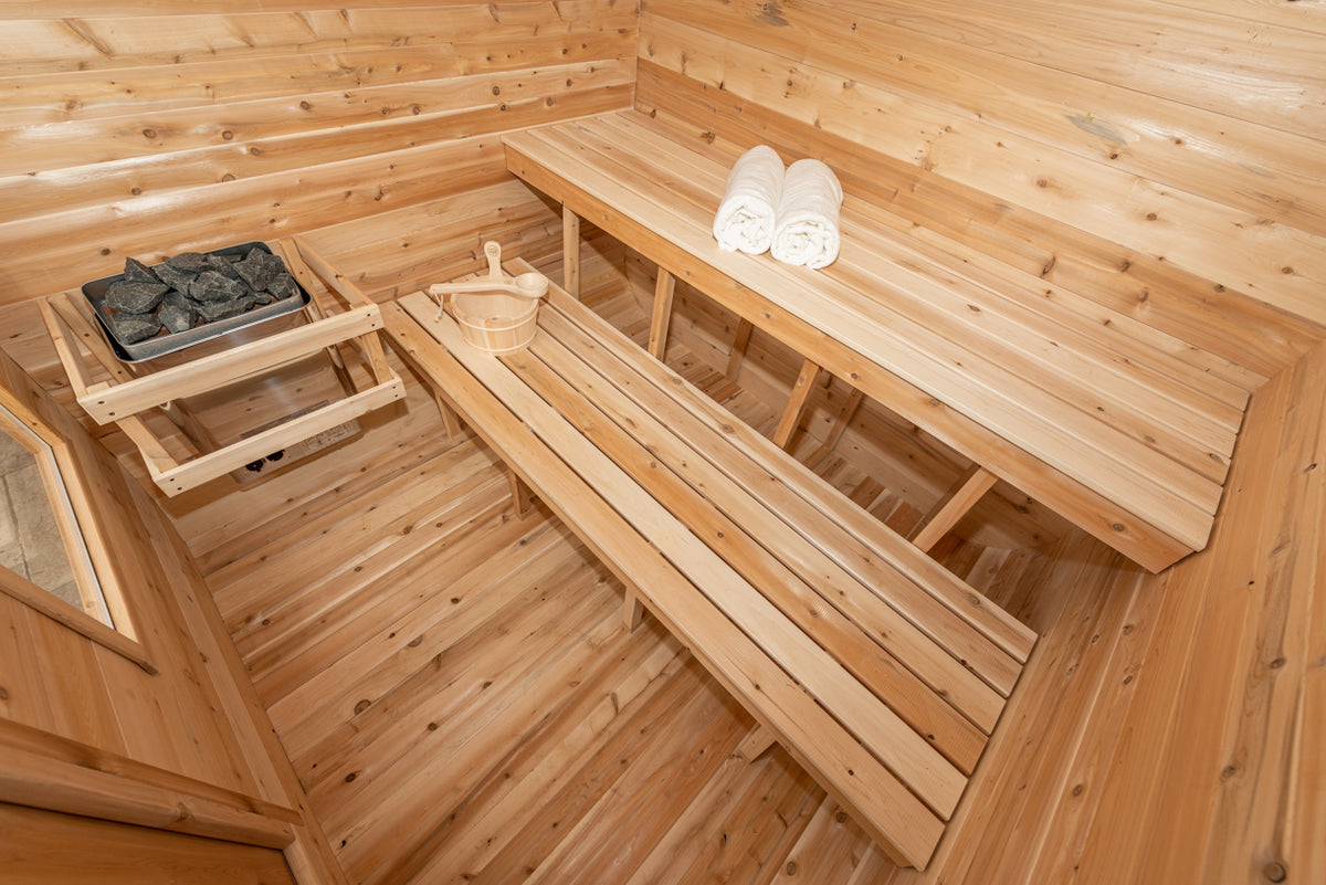 Interior view of Leisurecraft Canadian Timber Luna Outdoor Sauna, showing its benches and heater.