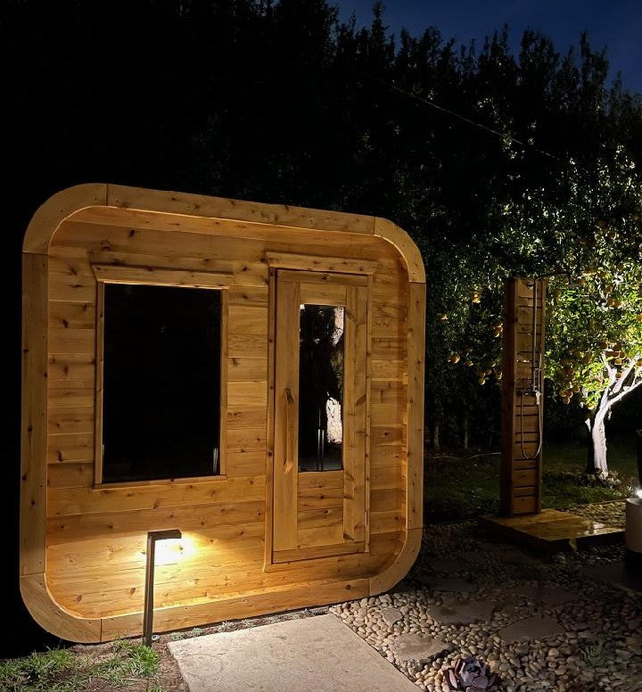 Leisurecraft Canadian Timber Luna Outdoor Sauna in an outdoor setting at night.