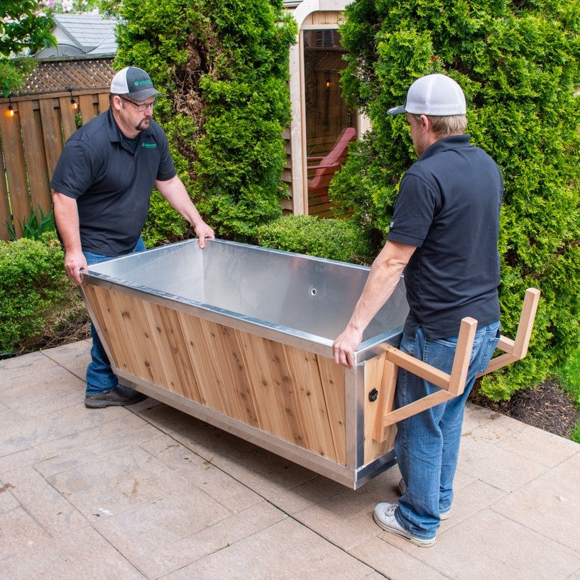 Two men carrying a Leisurecraft Canadian Timber Polar Cold Plunge Tub, showing is easy of being moved given its lightweight but robust design.