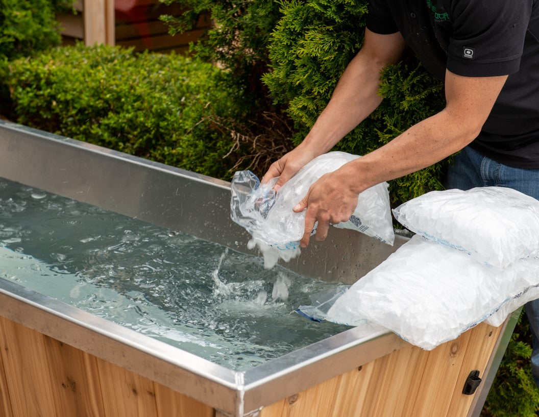 A man preparing a cold therapy session with Leisurecraft Canadian Timber Polar Cold Plunge Tub by adding ice into the water. 