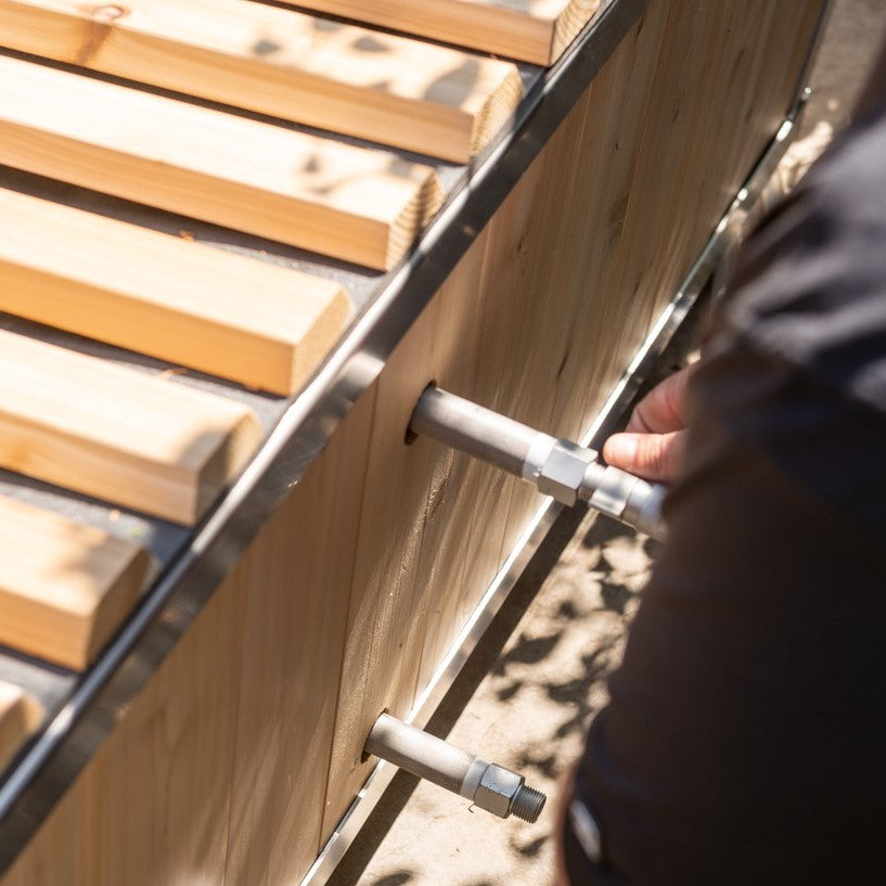 A man installing the Leisurecraft Canadian Timber Polar Cold Plunge Tub, showing how easily is done.