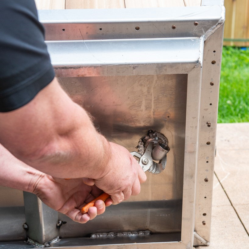 A man installing the Leisurecraft Canadian Timber Polar Cold Plunge Tub, showing how easily is done.