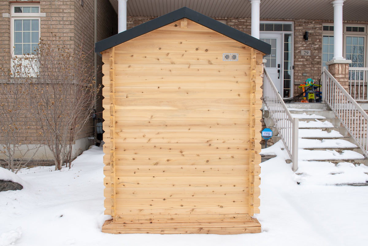 Back view of Leisurecraft Canadian Timber Granby Cabin Outdoor Sauna in a winter outdoor setting with snow.