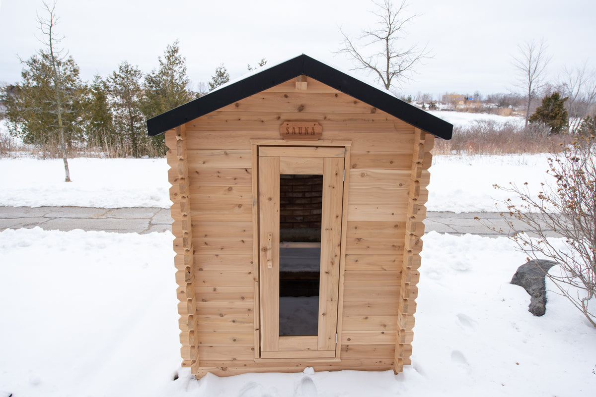 Front view of Leisurecraft Canadian Timber Granby Cabin Outdoor Sauna in a winter outdoor setting with snow.