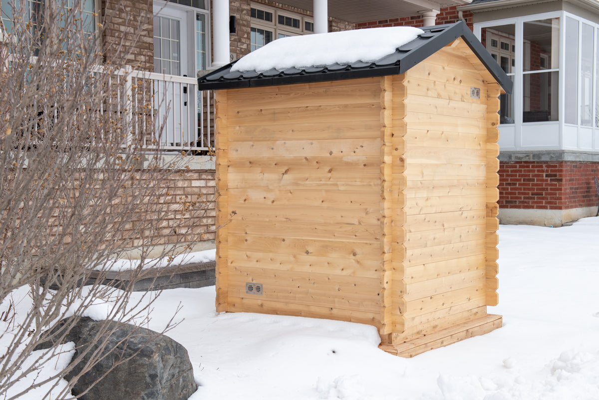 Side view of Leisurecraft Canadian Timber Granby Cabin Outdoor Sauna in a winter outdoor setting with snow.