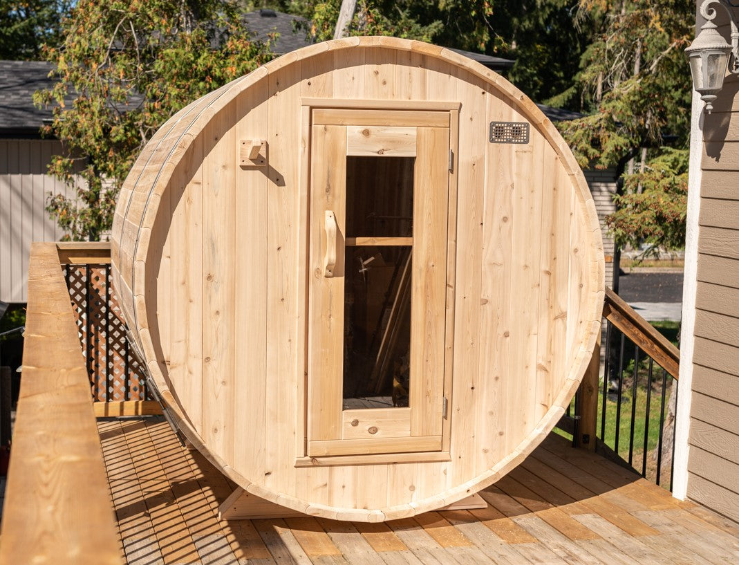 Front view of Leisurecraft Canadian Timber Harmony Barrel Sauna in an outdoor setting on a sunny day.