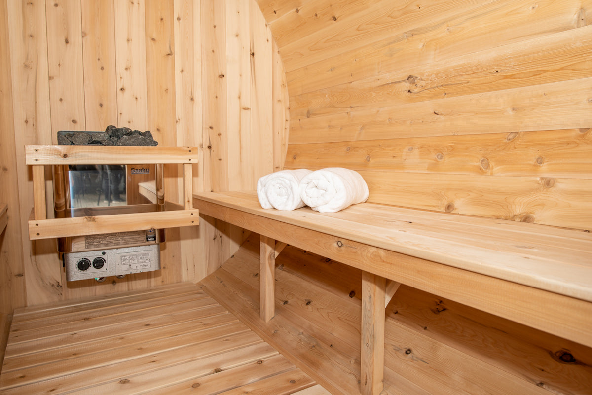 Close-up view of the benches and heater of Leisurecraft Canadian Timber Harmony Barrel Sauna.