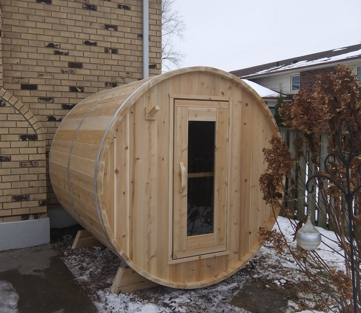 Leisurecraft Canadian Timber Harmony Barrel Sauna in an outdoor setting during winter.