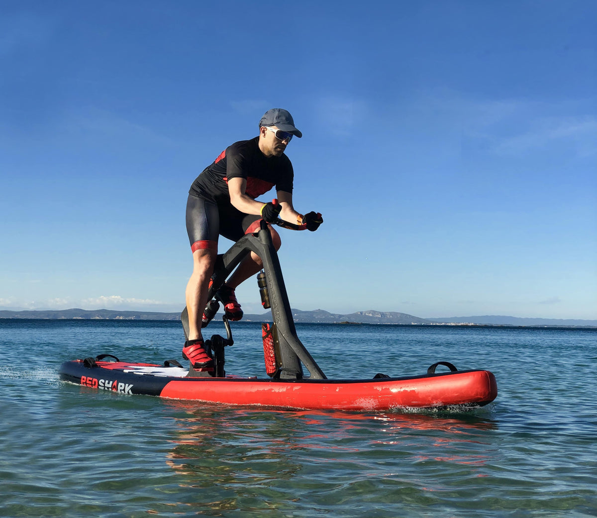 Man actively riding a Red Shark Fitness Bike Surf on the sea with clear skies.