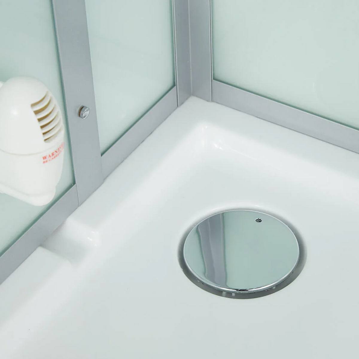 Close-up view of the drain of Maya Bath Platinum Arezzo Steam Shower white version.