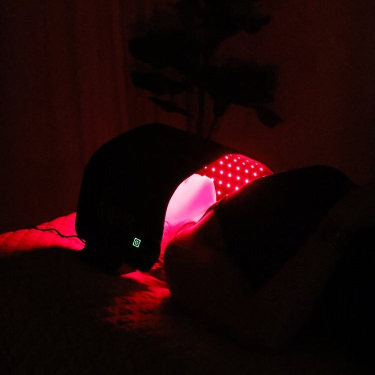 ORB Facial Light &amp; Therapy Wrap in a dimly lit room, emphasizing the calming red light therapy environment.