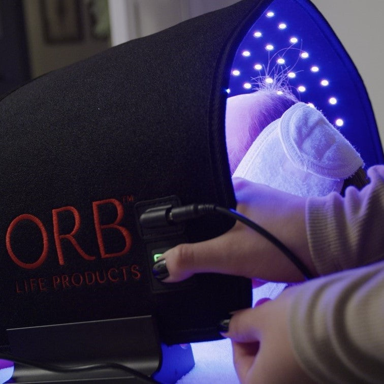 Close-up of ORB Facial Light &amp; Therapy Wrap in use, displaying the soothing effect of red light therapy on skin.