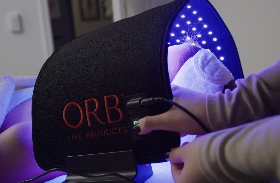 Side view of a user with ORB Facial Light &amp; Therapy Wrap, highlighting the ergonomic design for comfortable red light therapy.