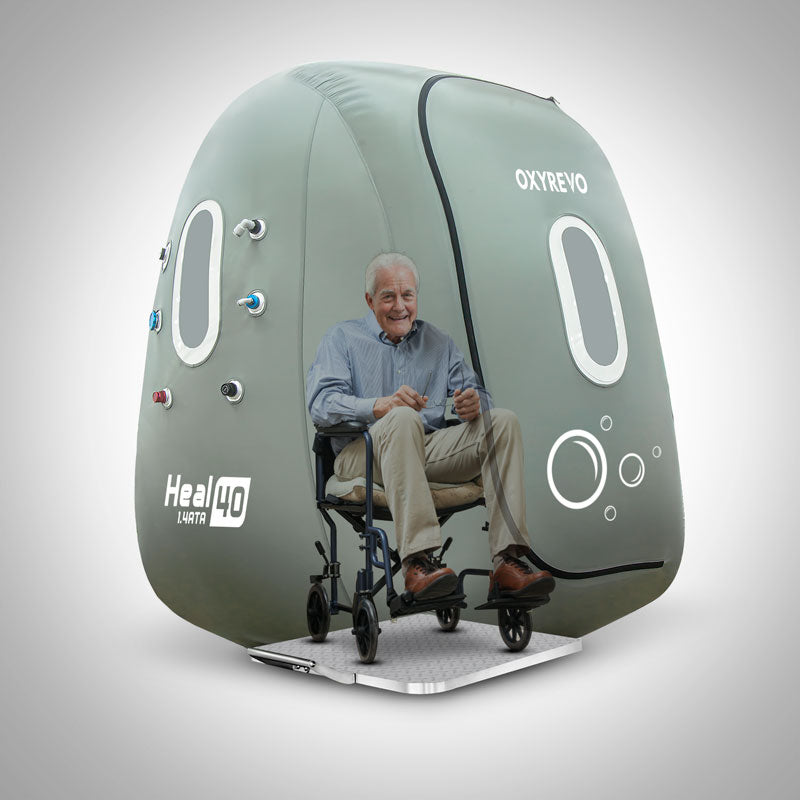 A man on a wheelchair inside an OxyRevo Wheelchair Heal 40 1.4 ATA Hyperbaric Chamber.