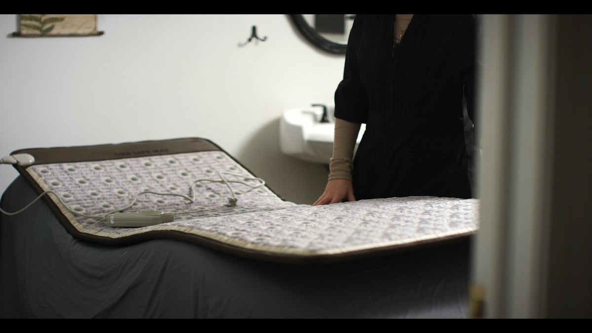 ORB PEMF Mat set on a massage table, ready for use, featuring PEMF and infrared technologies for health and recovery.