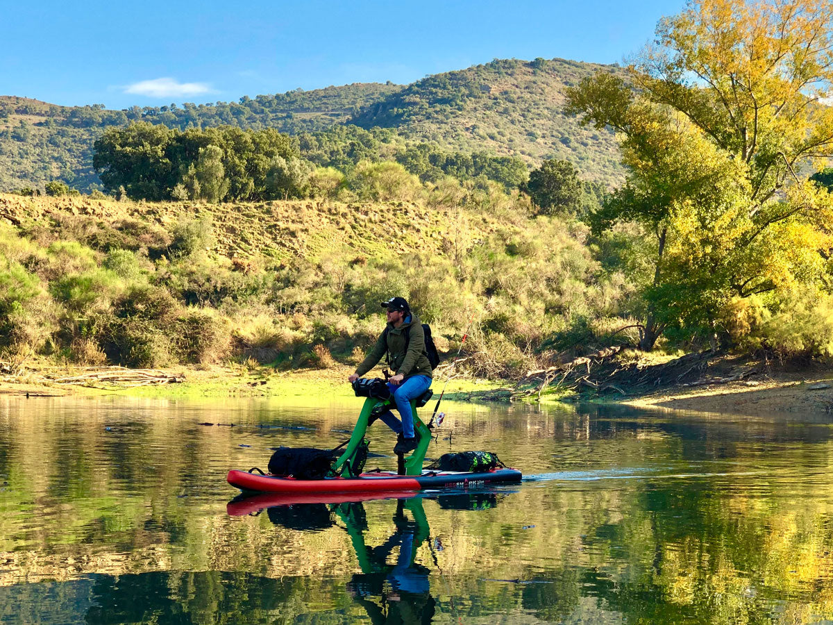 Exploring the river on a Red Shark Adventure Bike Surf with lush greenery in the background.