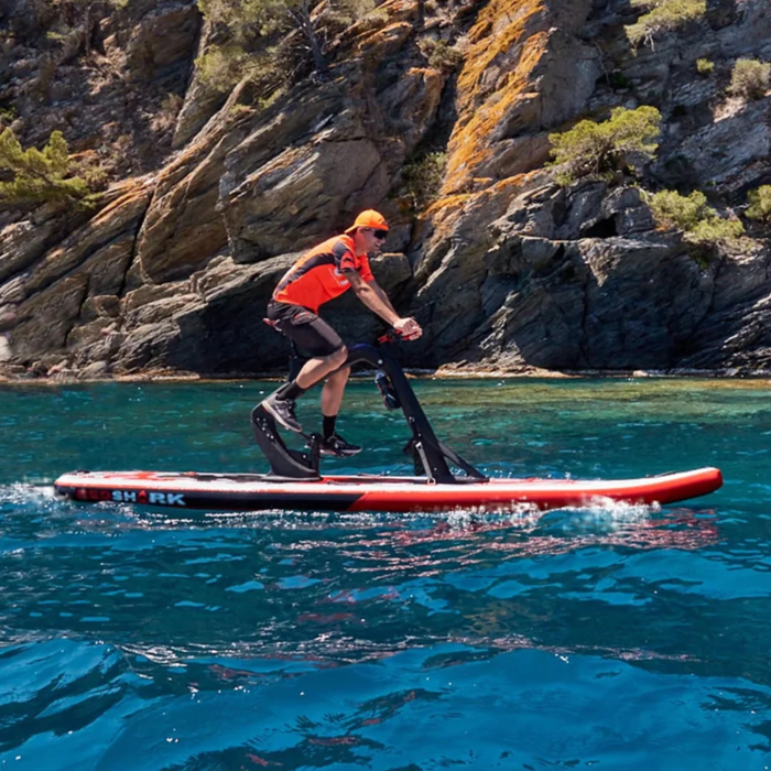 Active rider on a Red Shark Fitness Bike Surf paddling along the rocky sea cliffs.