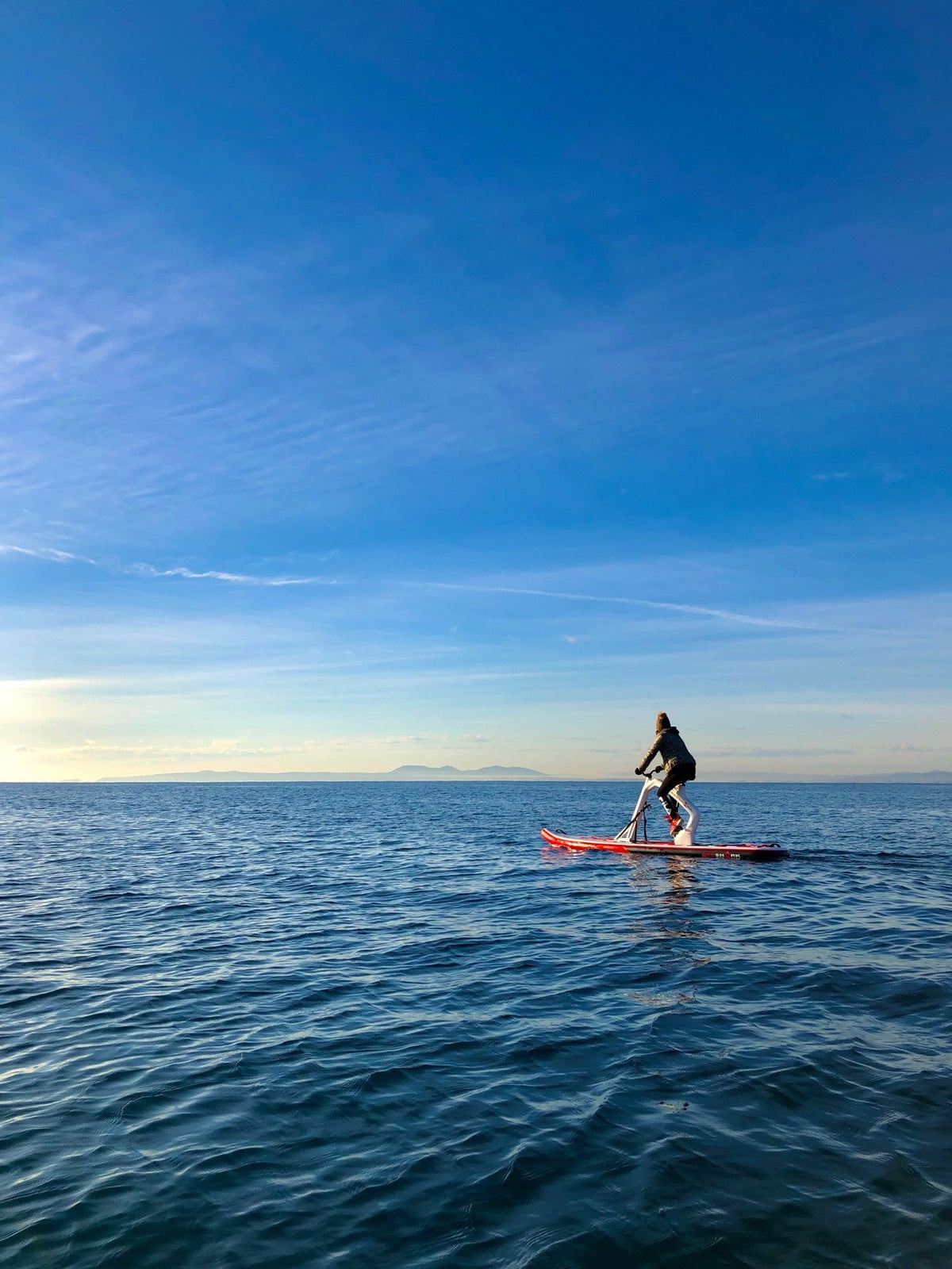 Rider on a Red Shark Enjoy Bike Surf on open water under a clear blue sky. 