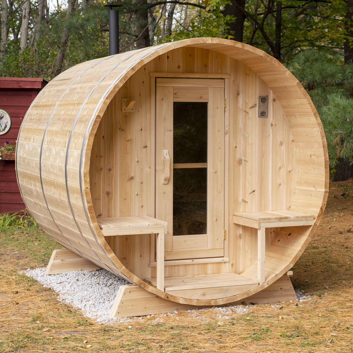 Diagonal view of Leisurecraft Canadian Timber Outdoor Barrel Sauna in an outdoor setting surrounded by forest.