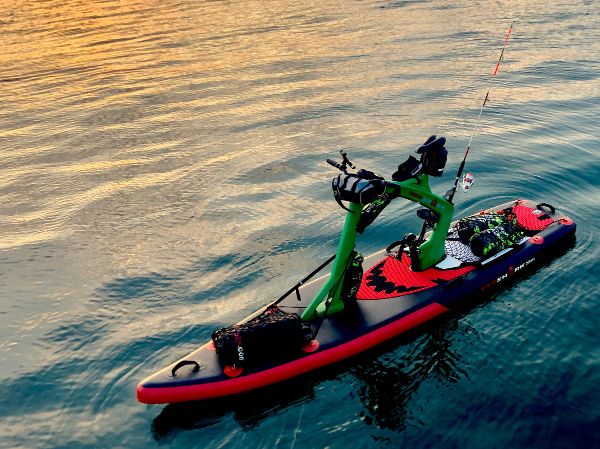 Fishing at sunset with the Red Shark Adventure Bike Surf on tranquil waters.