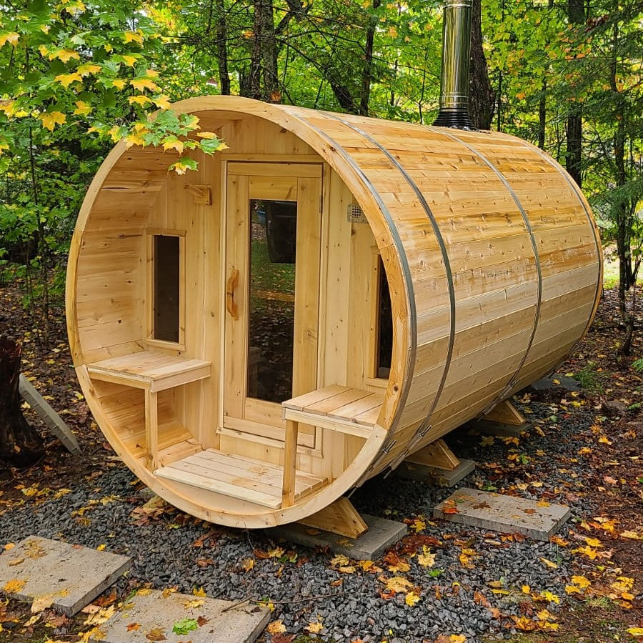 Leisurecraft Canadian Timber Tranquility Outdoor Barrel Sauna in the middle of the forest with a wood burning heated installed.